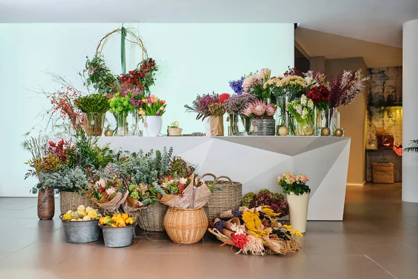 Geassorteerde Verse Kleurrijke Bloeiende Bloemen Vazen Rieten Manden Geplaatst Toonbank — Stockfoto