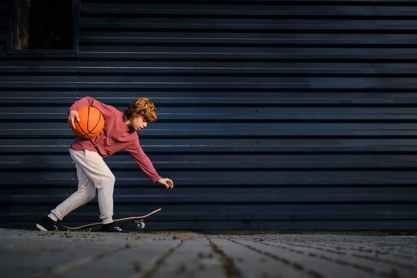 Тело Мальчика Баскетбольным Мячом Изгиб Возле Скейтборда Проводя Время Улице — стоковое фото