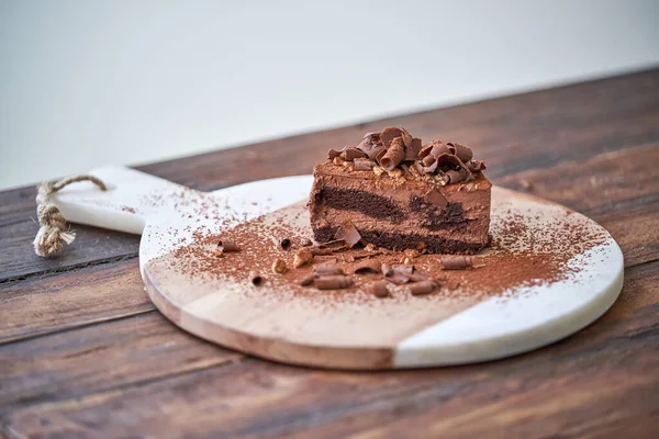 Вкусный Шоколадный Торт Украшенный Какао Порошком Стружкой Подаваемый Разделочной Доске — стоковое фото