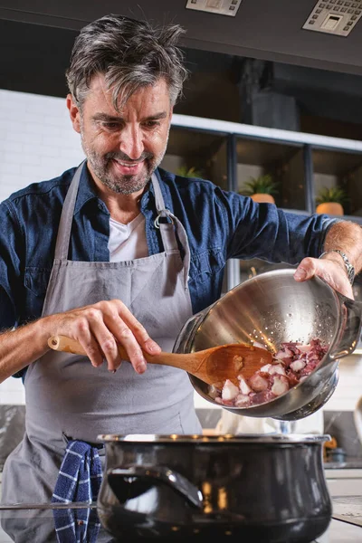 Positive Male Chef Apron Standing Stove Pouring Octopus Saucepan While — Stock Photo, Image