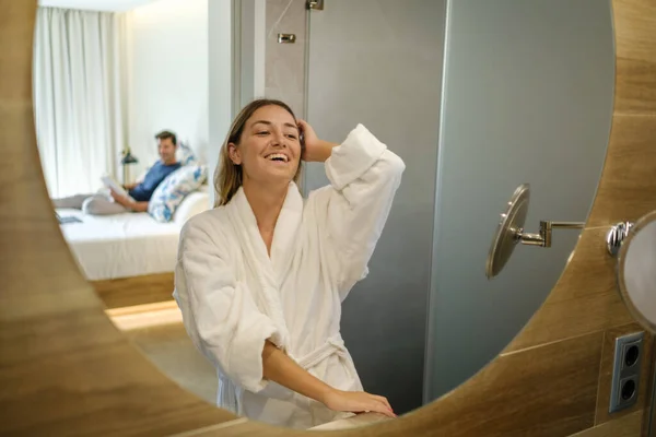 Beyaz Bornozlu Kadın Aynaya Bakıyor Saçlarına Dokunuyor Arada Banyoda Sabah — Stok fotoğraf