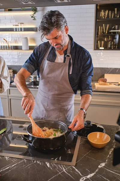 Chef Masculin Concentré Dans Tablier Debout Cuisinière Près Une Personne — Photo