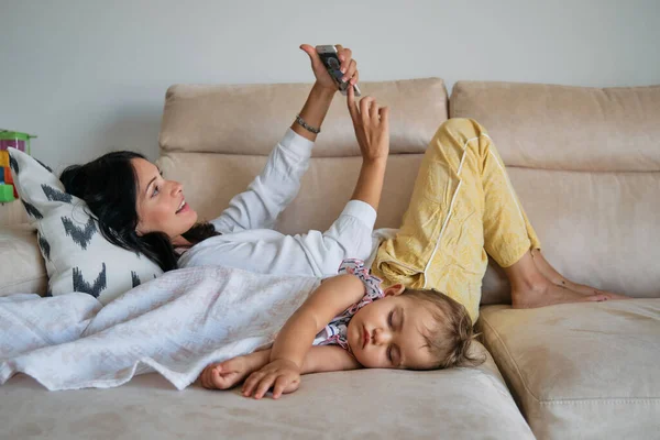 Joven Madre Acostada Mientras Toma Selfie Lindo Bebé Descansando Sofá —  Fotos de Stock
