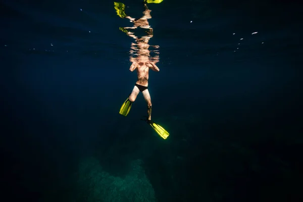 日中の青い海の下でダイビングスリッパで認識できない男性スイマーの全長 — ストック写真