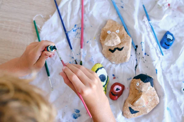 Crop Faceless Kid Using Watercolors While Painting Funny Faces Stones — Stock Photo, Image