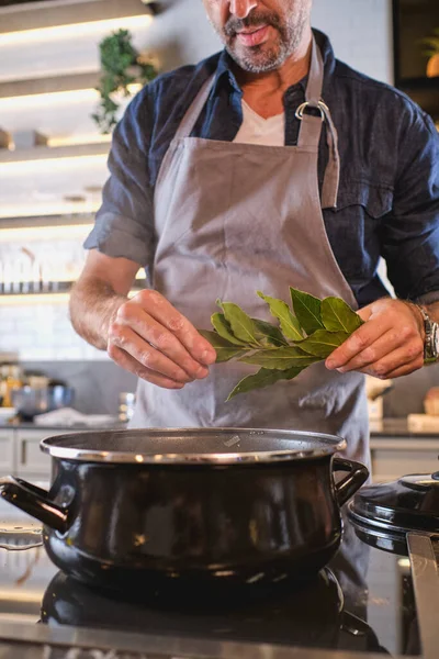 Professional Male Chef Standing Stove Holding Bunch Bay Leaves While — Stock Photo, Image