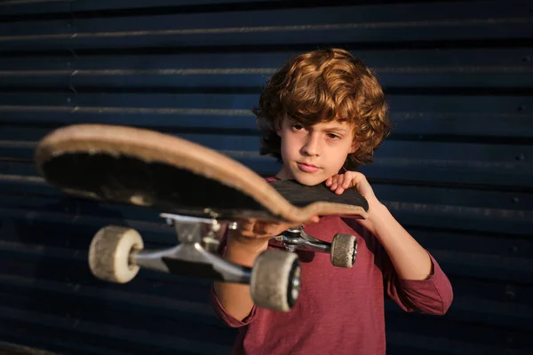 Boy Curly Hair Checking Skateboard Dark Blue Wall While Practicing — Stock Photo, Image