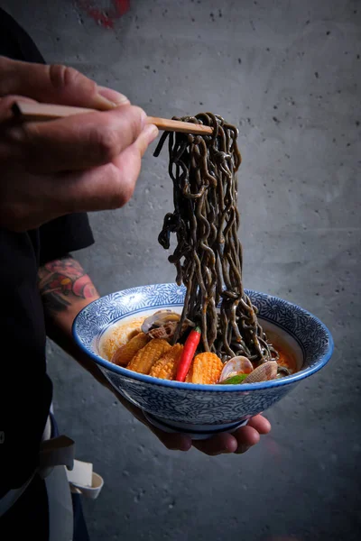 Male Hand Picking Black Noodles Bowl Hot Ramen Fish Broth — Stock Photo, Image