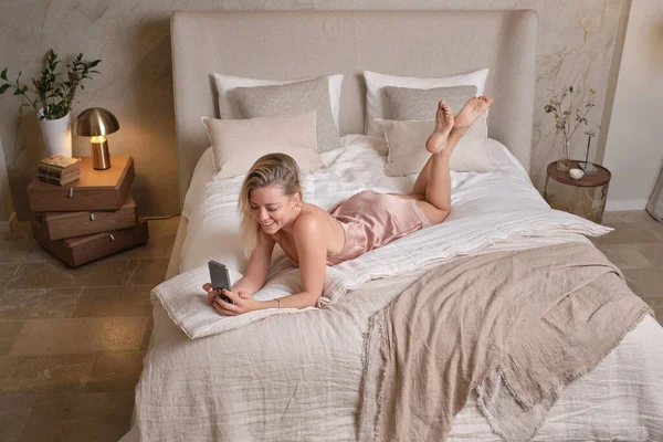 Haut Femme Souriante Nuisette Couchée Dans Lit Confortable Naviguant Smartphone — Photo
