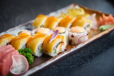 Güzel sunulmuş suşi parçalarıyla dolu bir tepsi.