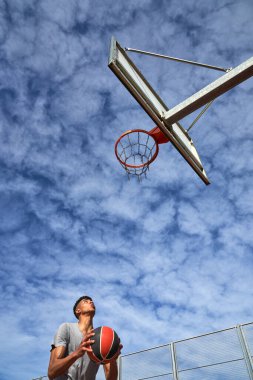 Düşük açılı erkek basketbolcu yüzüğe bakıyor ve yaz aylarında basket oynamaya hazırlanıyor.