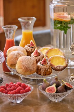 Toplantı odasındaki ahşap masada servis edilen lezzetli kek ve meyve suyu seti.