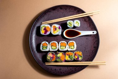Bir tabak sebzeli suşi, zengin ve lezzetli suşi çeşitleri yemek için mükemmel.
