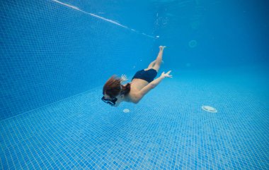 Mayolu ve google 'da yüzen, bilardo oynayan, dibi sürülmüş bir çocuk.