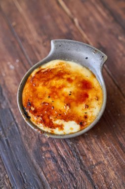 Lezzetli pirinç pudinginin tepesinden malzemelerle kavrulurken ahşap masaya konulmuş ve servis edilmeye hazır.