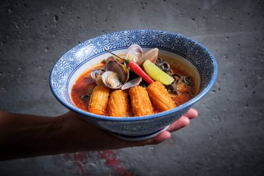 Tipik sıcak ramen çorbası içinde balık çorbası ile siyah erişte, kalamar, acı biber ve midye..