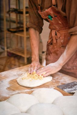 Genç erkek fırıncı ekmek yapmak için hamur hazırlıyor. Yüksek kalite fotoğraf