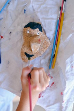 Evdeki masadaki kayanın üzerinde boya fırçası resmi olan isimsiz çocuğun en iyi görüntüsü.