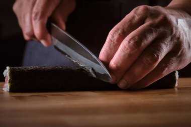 Erkek shushi adam elleri farklı Makis parçaları hazırlıyor.