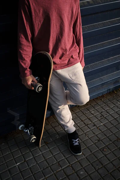 Сверху Анонимный Мальчик Скейтбордом Опирающимся Стену Отдыхающим Улице Города — стоковое фото