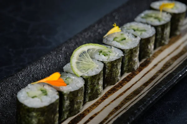 Row Delicious Sushi Rolls Served Dark Tray Placed Table Restaurant — Stock Photo, Image