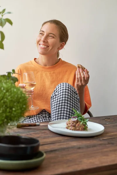 Sorrindo Jovem Fêmea Roupas Casuais Sentado Cozinha Acolhedora Olhando Para — Fotografia de Stock
