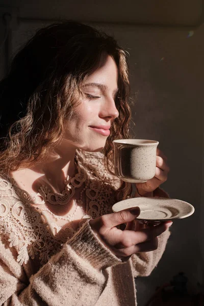 浅色房间里 金发碧眼的年轻女性享受着一杯热咖啡的侧影 — 图库照片