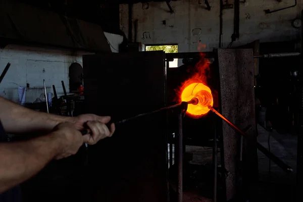 認識できない男性ガラスミスは 工場で働いている間 ホッカ花瓶の先端に加熱ガラスで金属ブロープパイプを置く — ストック写真