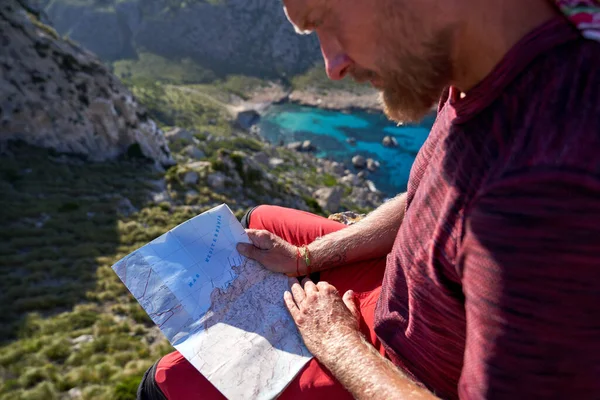 夏休みの間に山の中を旅しながら地図上のルートをチェック作物の男性旅行者のサイドビュー — ストック写真
