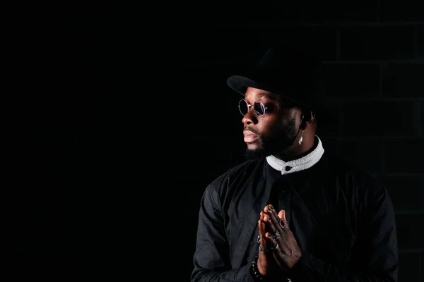 Seriöses Afroamerikanisches Männermodel Mit Gebetshänden Trendigen Schwarzen Outfit Das Vor — Stockfoto