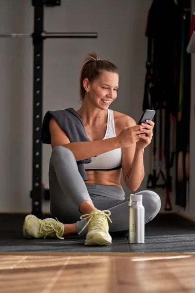 Volledige Lengte Van Volwassen Vrouwelijke Atleet Sportkleding Glimlachen Surfen Smartphone — Stockfoto
