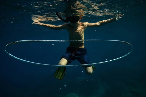 シュノーケリングマスクの認識できないシャツレスダイバーと水中大きなバブルリングの近くで泳ぐスリッパ — ストック写真