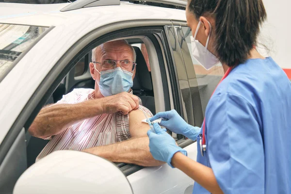 Lekarz Mundurze Dotykający Ramię Starszego Kierowcy Serwetką Medyczną Przed Zaszczepieniem — Zdjęcie stockowe