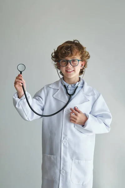Cute Kid Mundurze Medycznym Okulary Stetoskopem Patrząc Aparat Fotograficzny Białym — Zdjęcie stockowe