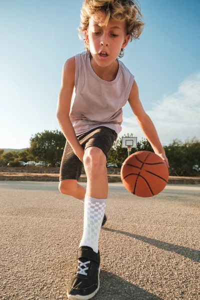 Ganzkörper Lockiges Kind Sportbekleidung Das Ball Zwischen Die Beine Wirft — Stockfoto