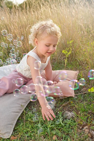 Χαριτωμένο Κοριτσάκι Κομψό Φορούν Παίζει Σαπουνόφουσκες Ενώ Κάθεται Ζεστό Μαξιλάρια — Φωτογραφία Αρχείου