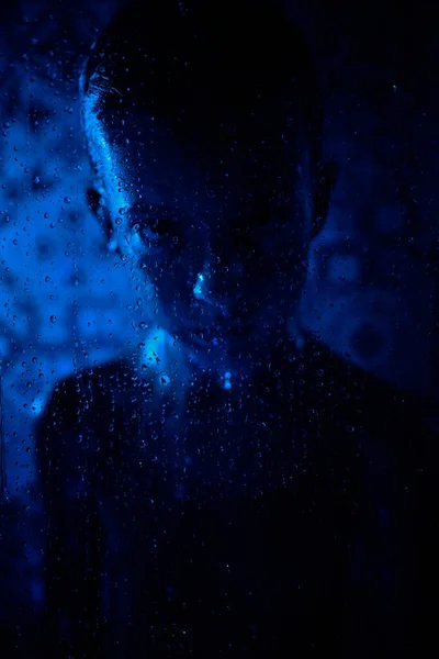 Mutsuz Çocuk Cam Duvarın Arkasında Mavi Neon Işıkta Damlatan Kameraya — Stok fotoğraf