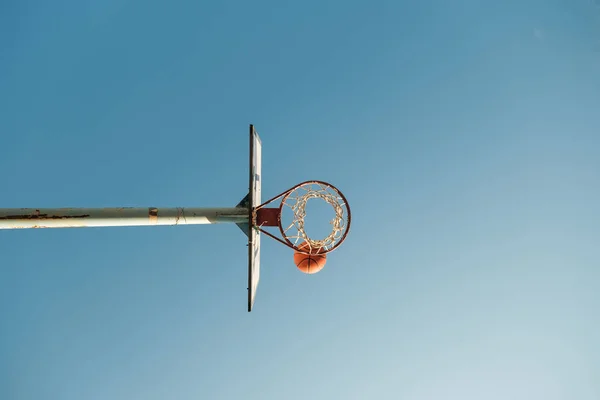 Basketbol Potasının Altından Halkalı Bulutsuz Gökyüzüne Karşı Turuncu Top — Stok fotoğraf