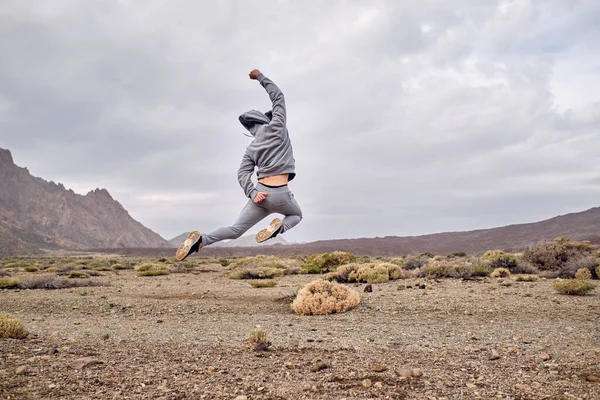 西班牙加那利群岛特内里费火山附近干枯的石质地形上跳跃的身躯全身裸体男子 — 图库照片