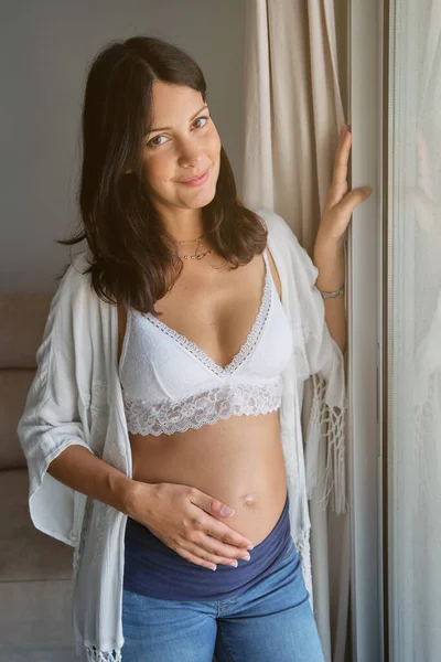 Young Pregnant Female White Bra Jeans Smiling Caressing Tummy Tenderness — Stock Photo, Image