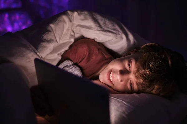 Оптимистичный Ребенок Снотворном Просматривает Таблетки Лежа Одеялом Постели Темной Спальне — стоковое фото