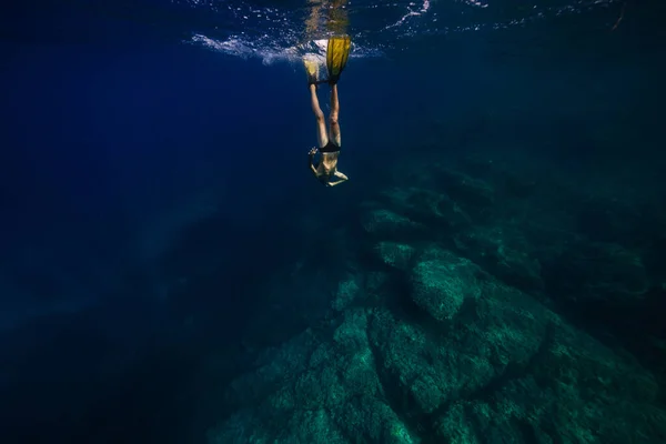 夏休み中にサンゴ礁に向かって深い青い海の下で泳ぐ 認識できない若いシャツレスの男性ダイバーの全身 — ストック写真
