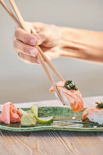 Beskær Anonym Person Spiser Lækker Sake Nigiri Sushi Med Spisepinde - Stock-foto