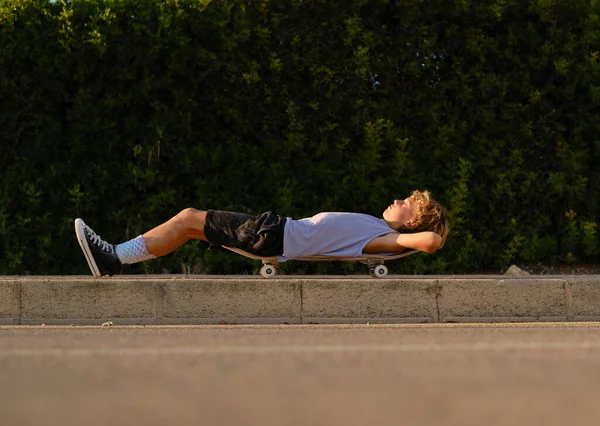 Vista Lateral Nível Solo Menino Pré Adolescente Deitado Skate Rua — Fotografia de Stock
