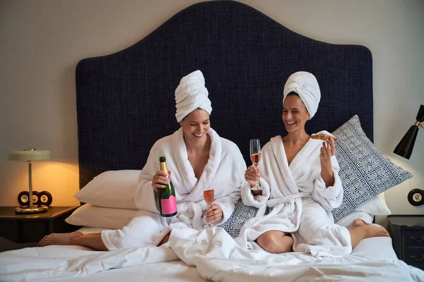 Vrolijke Vrouwelijke Vrienden Bed Badjassen Champagne Drinken Heerlijke Croissants Eten — Stockfoto