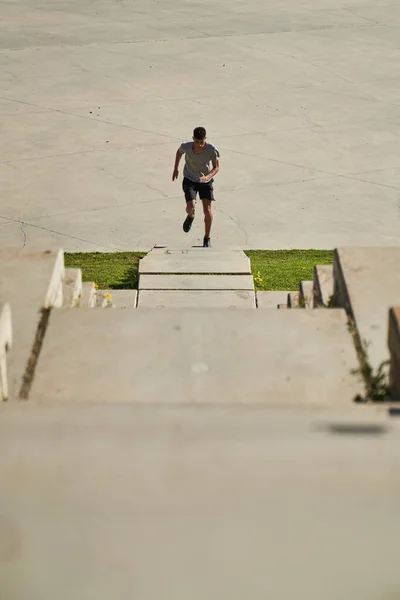 遠くの男性ランナーの上から積極的に石の階段を駆け上がって街の路上で激しいワークアウト中に — ストック写真