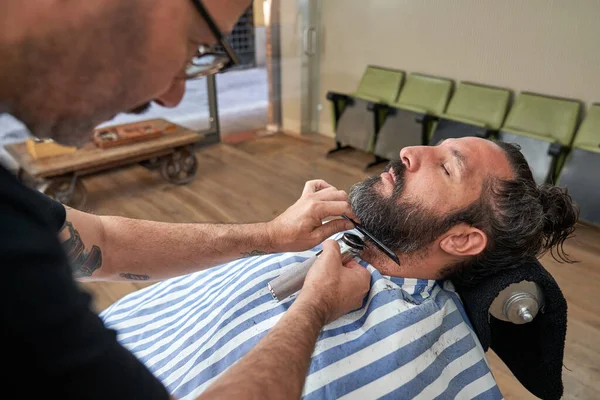 Widok Boku Męski Fryzjer Cięcia Brody Klienta Przycinaczem Podczas Pracy — Zdjęcie stockowe