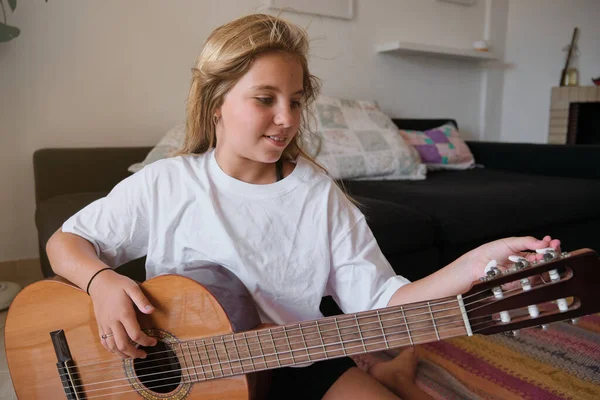 Beyaz Elbiseli Güzel Sarışın Kız Ahşap Akustik Gitarını Akort Ederken — Stok fotoğraf