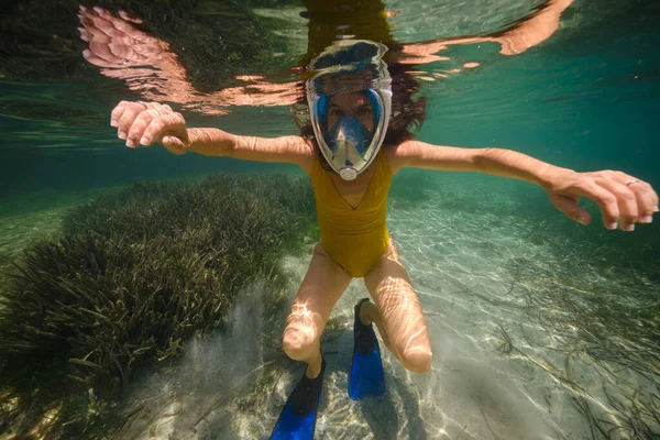 イビサの澄んだ海で泳ぐウェットスーツとシュノーケリングマスクの未知のダイバーの水中ビュー — ストック写真