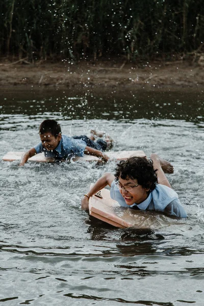 Niños Varones Alegres Uniforme Escolar Nadando Con Tabla Mientras Salpica —  Fotos de Stock